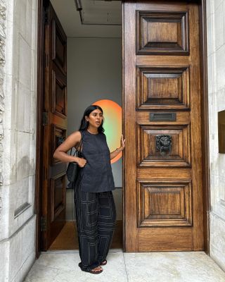 Monikh Dale wearing a black sleeveless top and Toteme silk pants