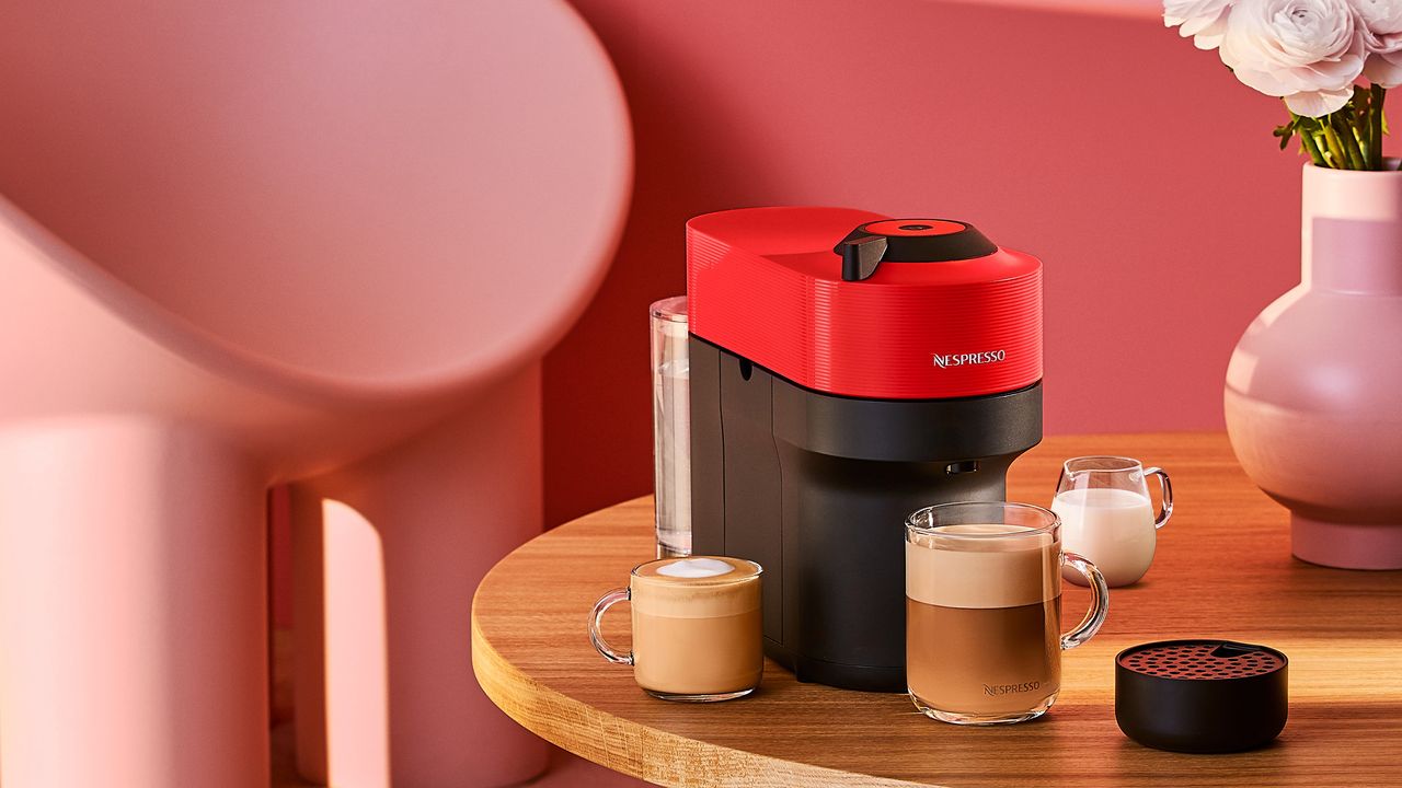 Nespresso Vertuo Pop machine on wooden table with prepared coffee 