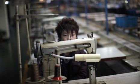 A laborer pauses as he works at a shoe factory in China: The cheap cost of Chinese labor may be a thing of the past.