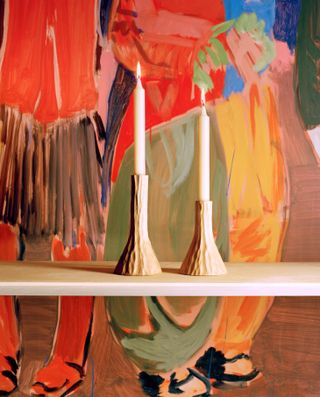 wooden candlesticks by Pierre Yovanovitch against the backdrop of a colourful painting