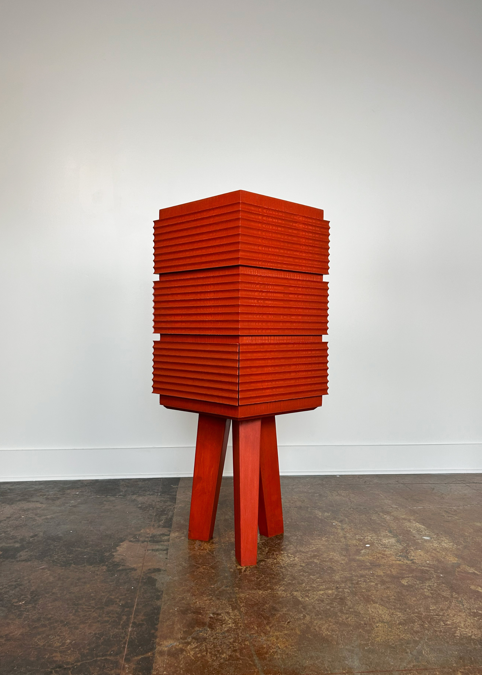 A ridged orange table with drawers