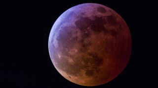 Bobby Bristoe astrophoto of the month winner September 2023. Lunar eclipse photograph showing a red and blue hued moon.