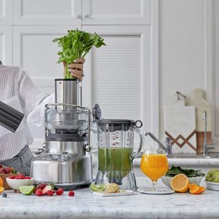 Sage 3X Bluicer on a worktop with woman adding celery