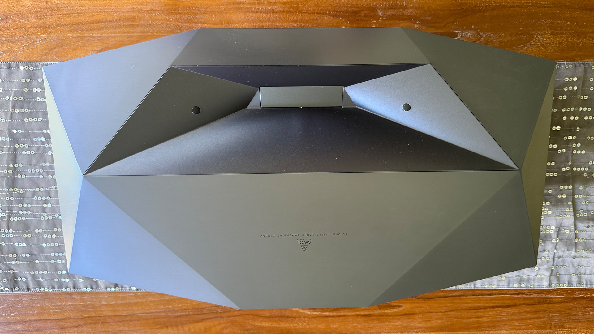AWOL Vision Aetherion Max ultra short throw projector on wooden table viewed from top