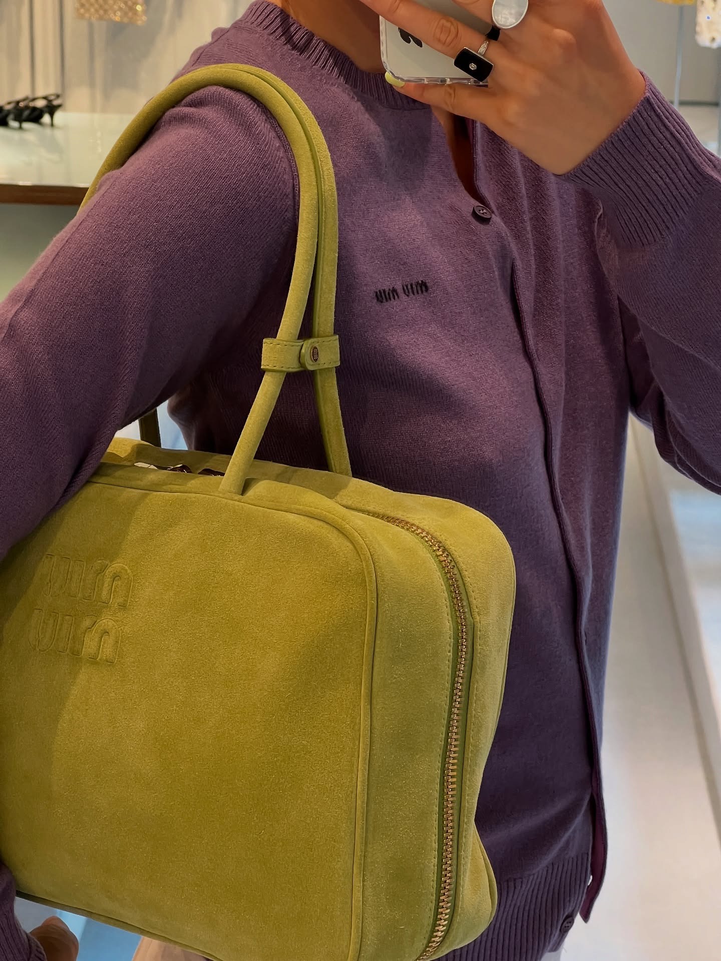 Woman in plum cardigan and lemongrass bag