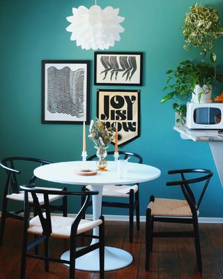 A clean and tidy teal dining area with a white table