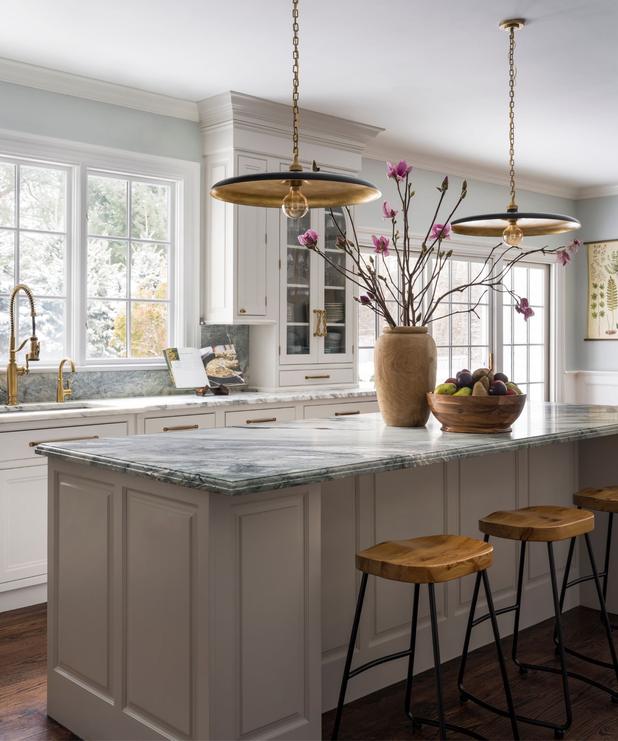 A white kitchen with shaker cabinets and marble countertops