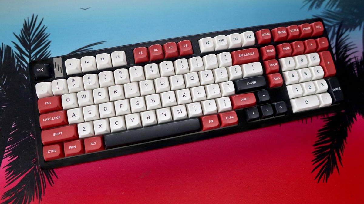 The Gamakay TK101 gaming keyboard in a red and white colourway and on a colourful mouse pad.