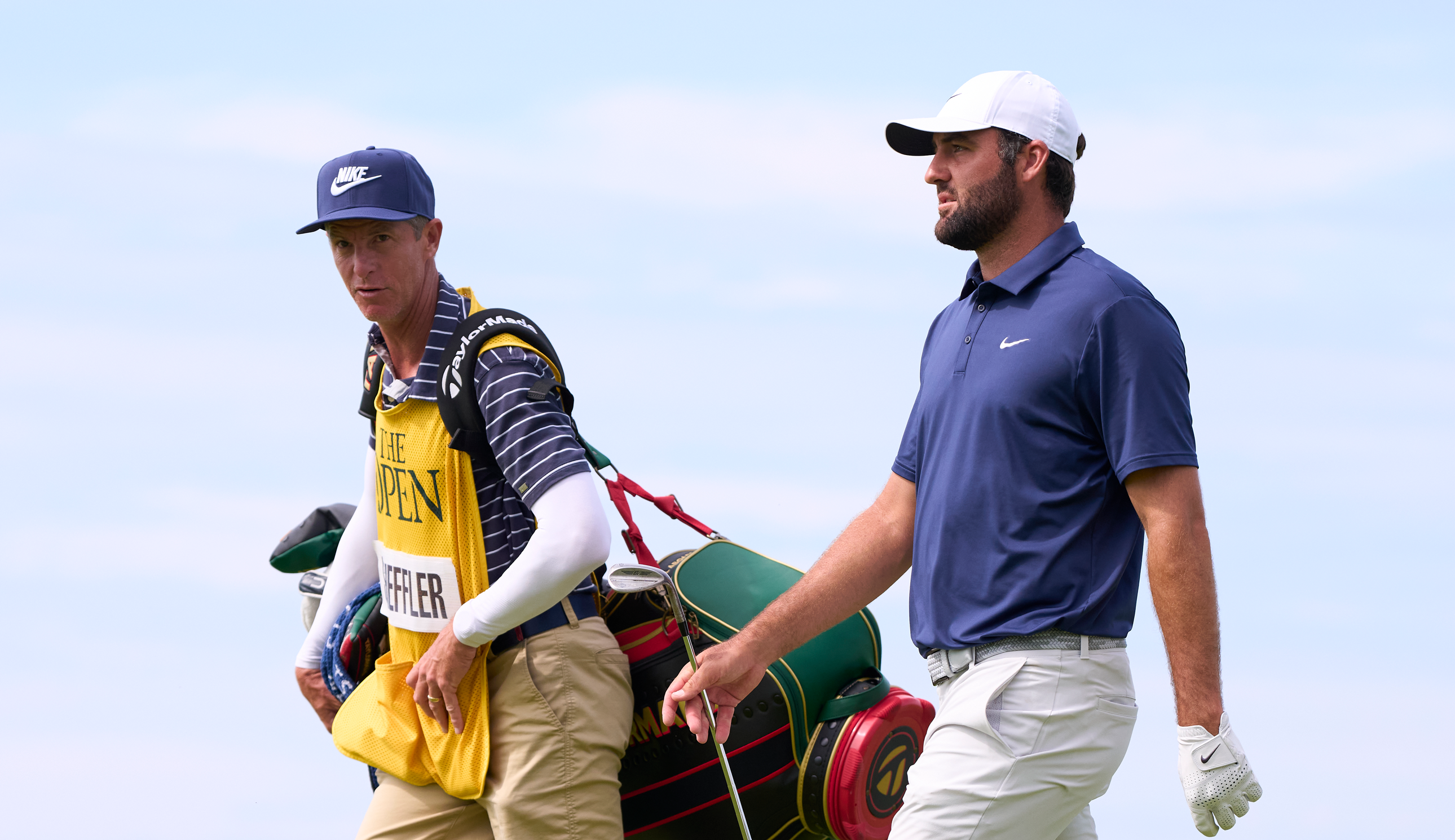 Scottie Scheffler walks down the fairway with Ted Scott