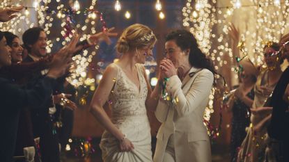 Two women walk down the aisle in a Zola commercial.