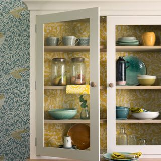 kitchen with yellow coloured wallpaper and crockery rack