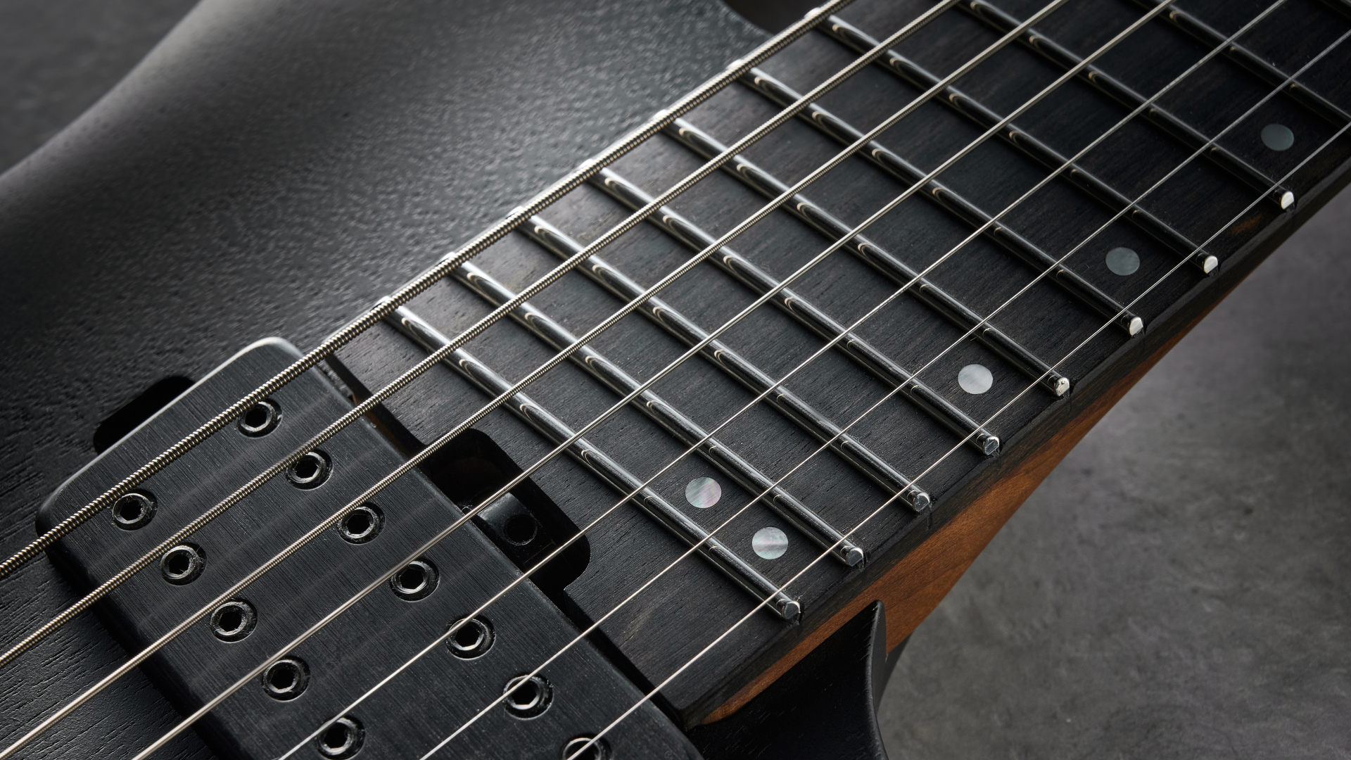 Ibanez QX527B headless guitar shot on grey surface