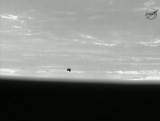 Photo of small Spherical Satellite with Earth in the background.