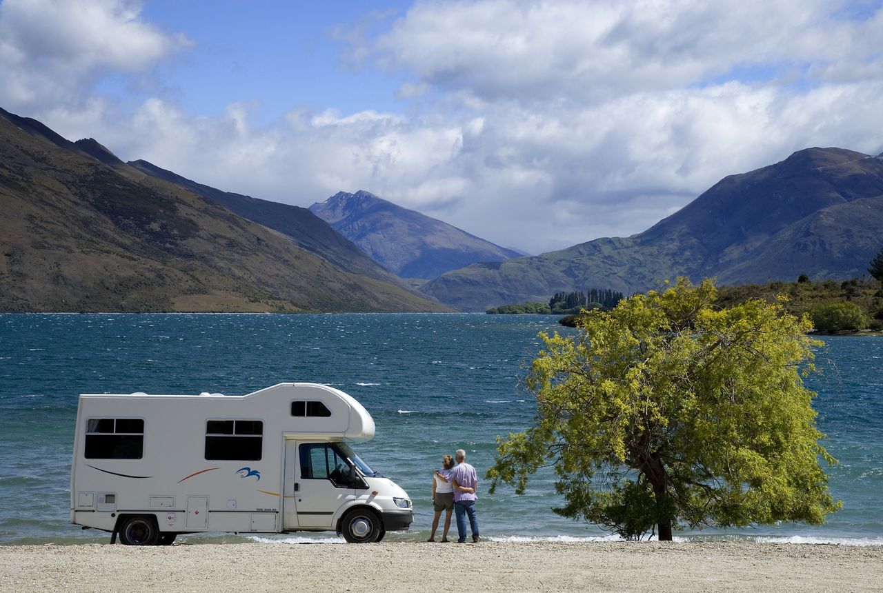 Couple outside RV looking at lake