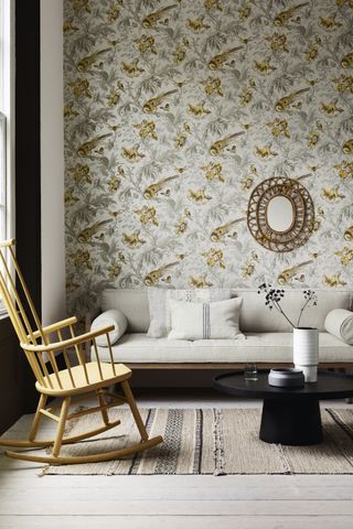 Canary feature wallpapered walls in bohemian lounge with white furnishings and wooden rocking chair
