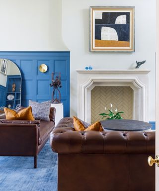 living room with brown leather sofas and blue accent wall
