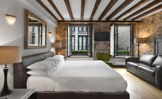 Guestroom with exposed beams & brick walls