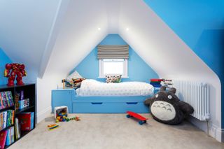 How to organize a kid's room with blue walls and fitted drawers under the bed