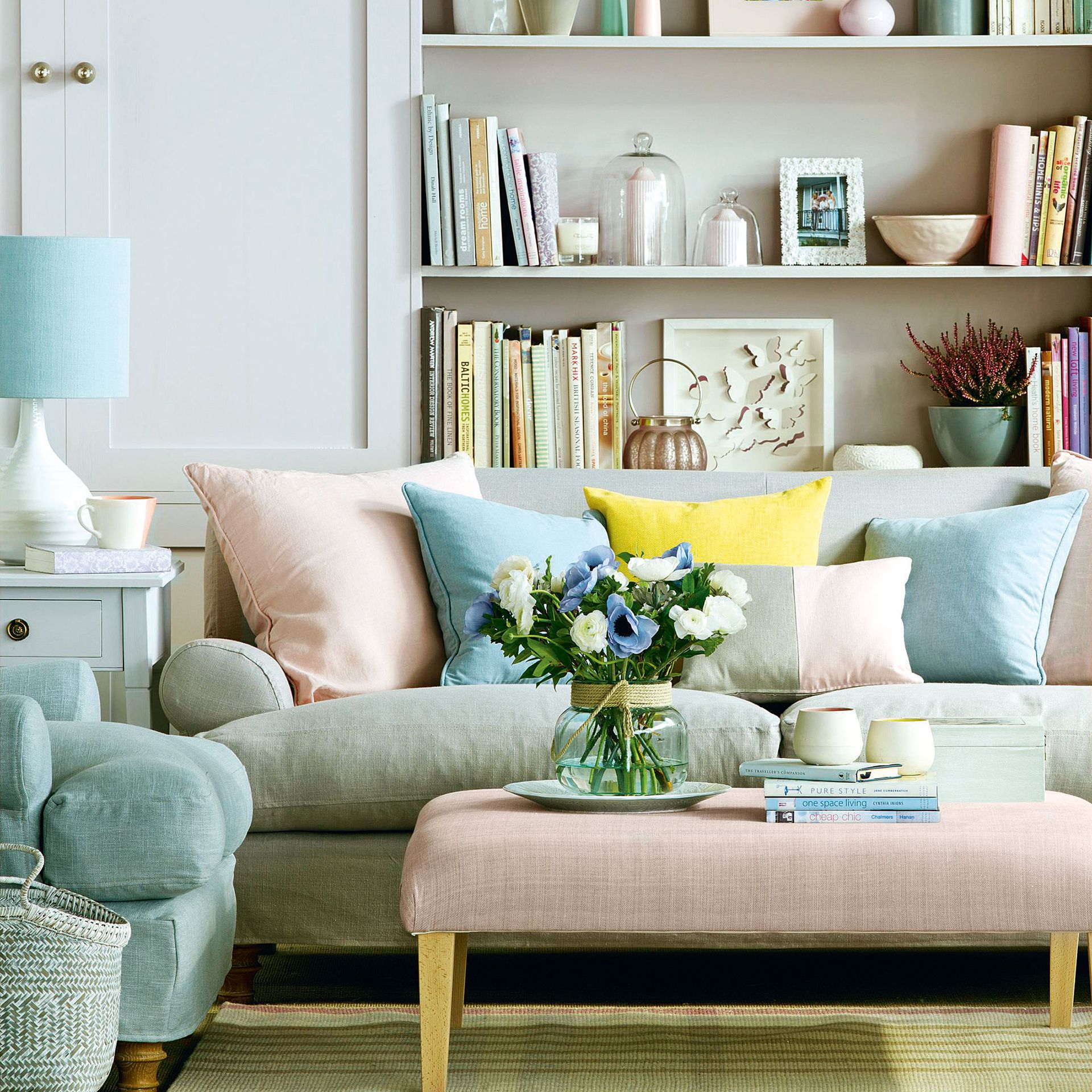 Grey sofa and pink ottoman in front of white built in bookshelves