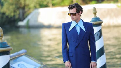 Harry Styles wearing a blue suit and sunglasses