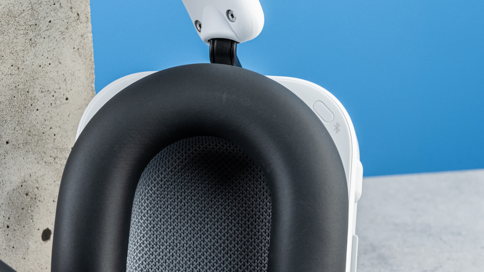 the nothing headphone (a) photographed against the blue tom's guide background, showing the transparent and white ear cups with red accents, the padded headband, and the accessories including 3.5mm jack