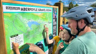 A familyvlooking at the gravelfoyle route map