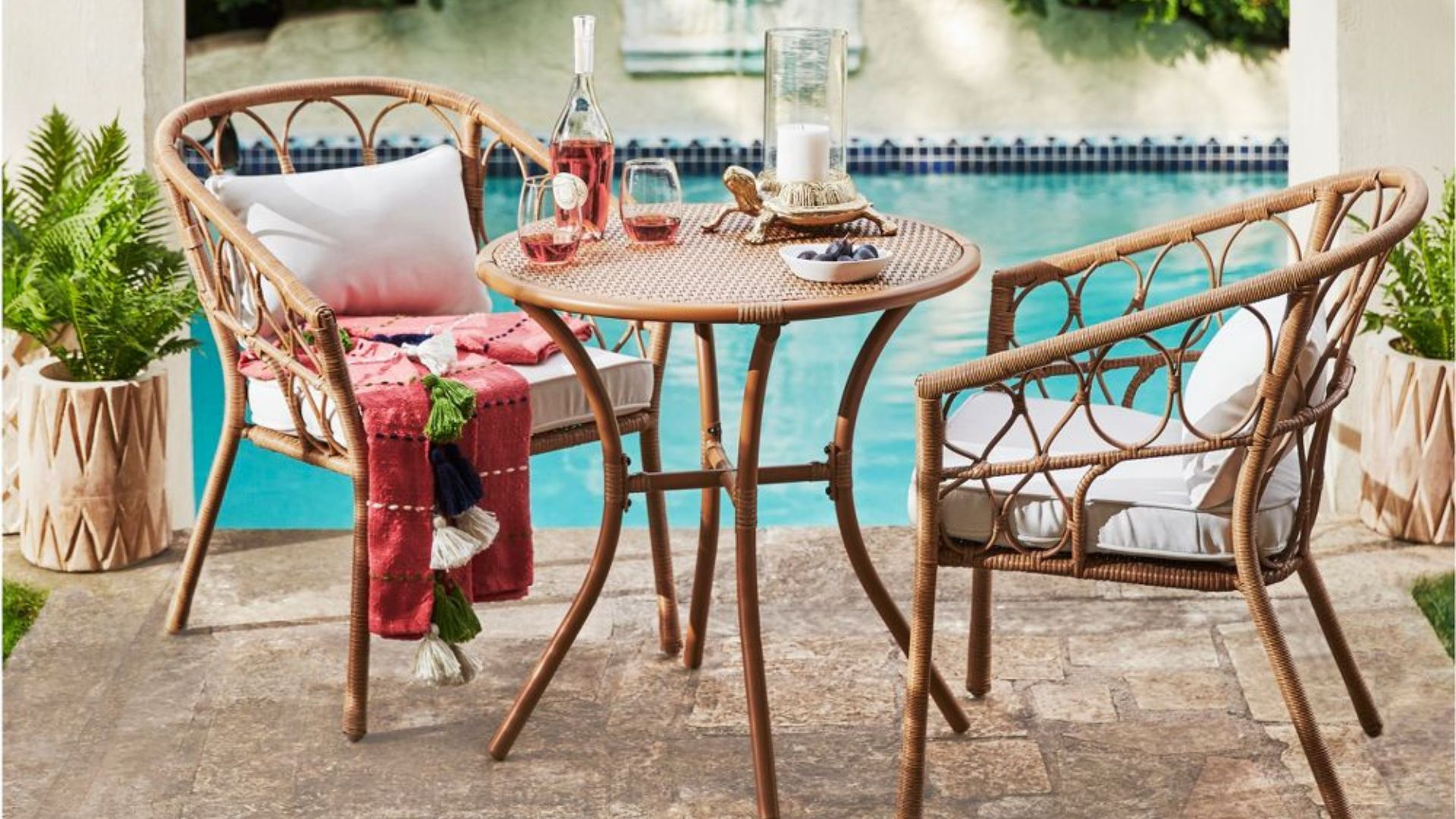 A Target patio bistro set with a pool in the background, for the best outdoor furniture brands.
