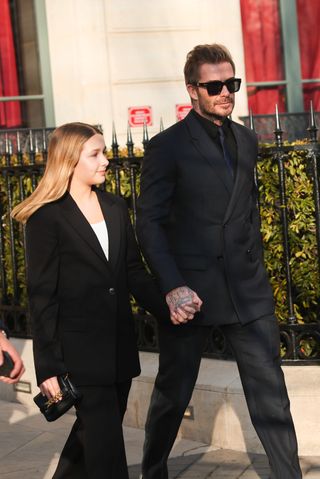 Harper Beckham and David Beckham walking