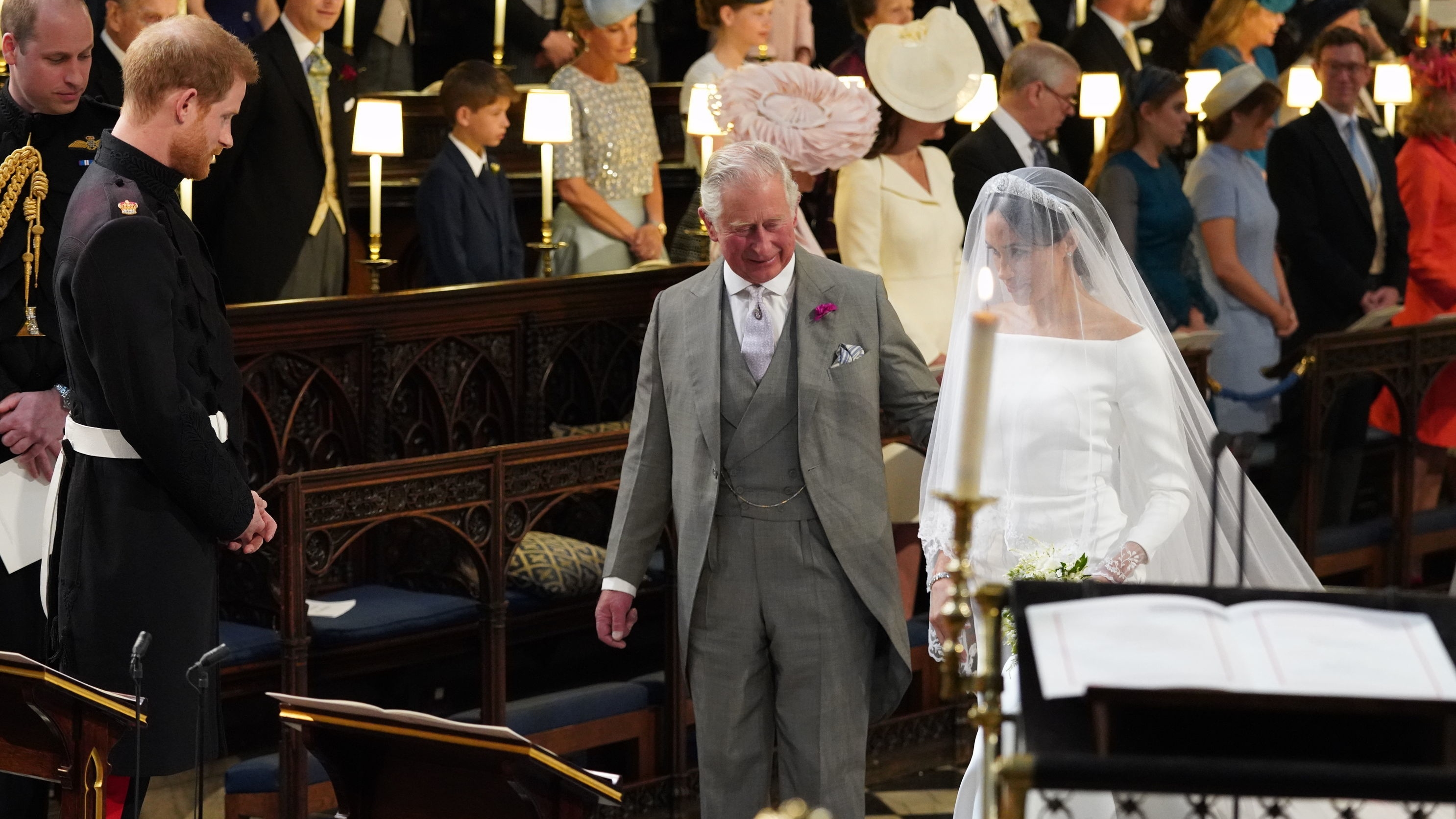 Prince Harry looks at Meghan Markle, as she arrives accompanied by King Charles during their wedding in St George's Chapel at Windsor Castle on May 19, 2018