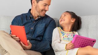 Amazon Fire HD 8 Kids Edition being used by a girl who is sitting next to a man, who is also using a tablet