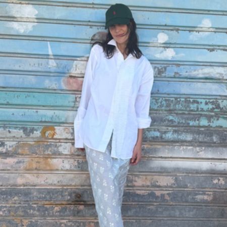Alexa Chung wears a midiskirt with black ballet flats and a white skirt.