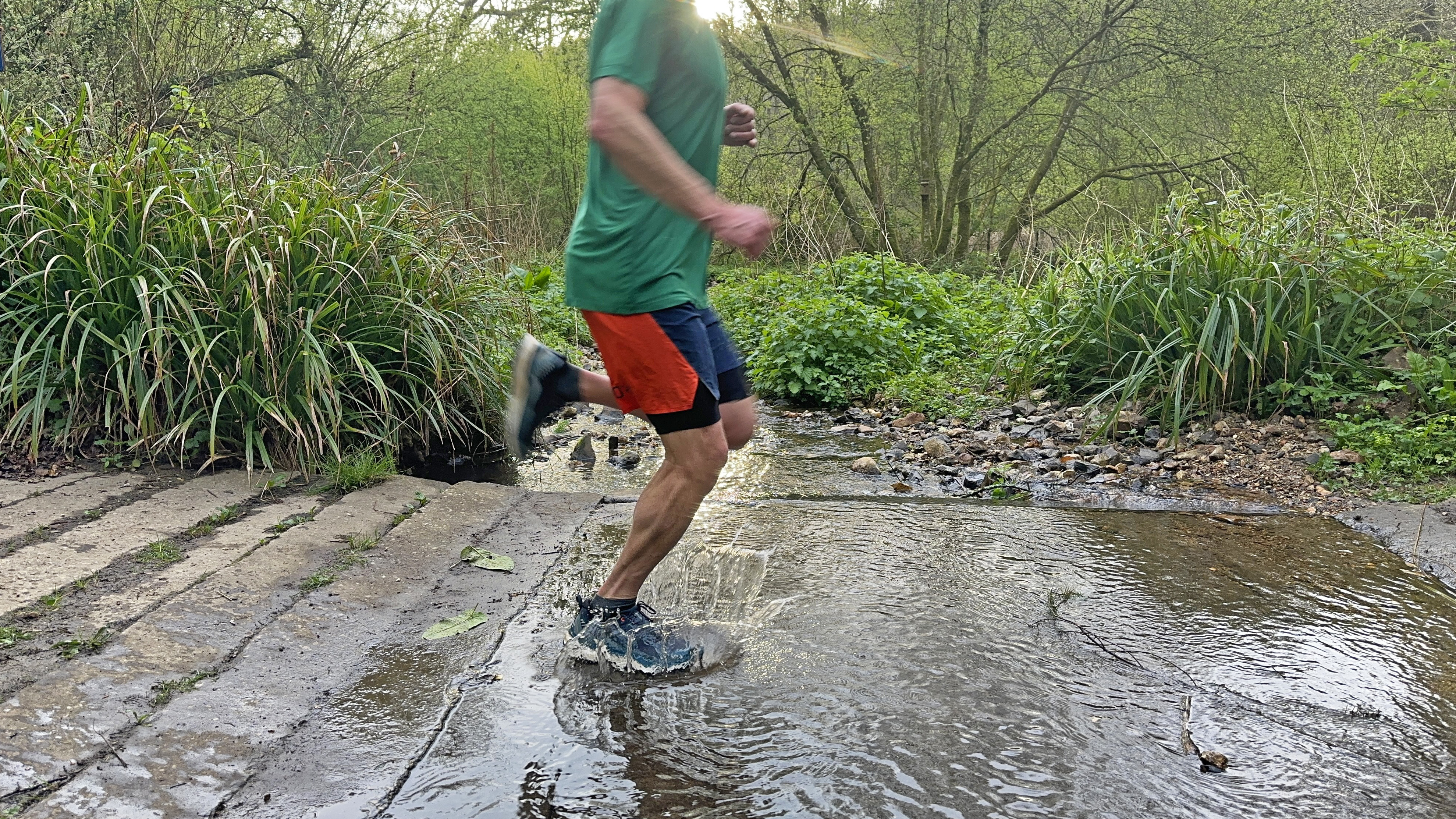 Runner doing a water crossing in the Lowa Skyterra