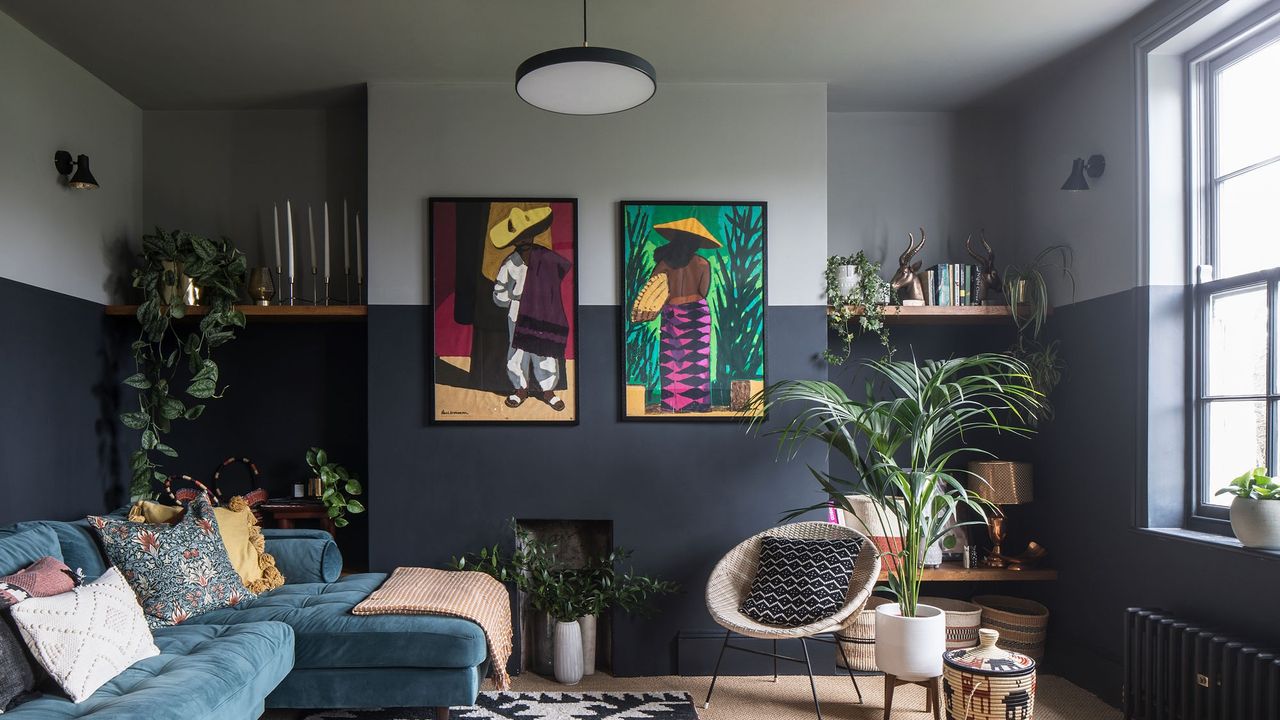 Maximalist style living room with a two tone wall, velvet sofa, colourful art on the wall, and assorted furniture.