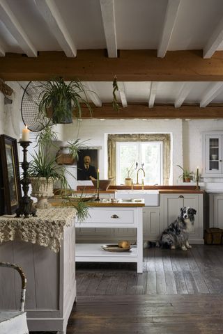 white kitchen with kitchen island and wooden beamed ceiling