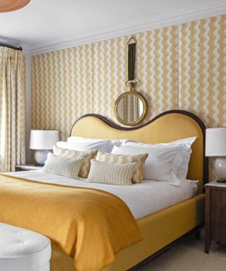 White and yellow bedroom with yellow bed, white bedding and yellow and white patterned wallpaper