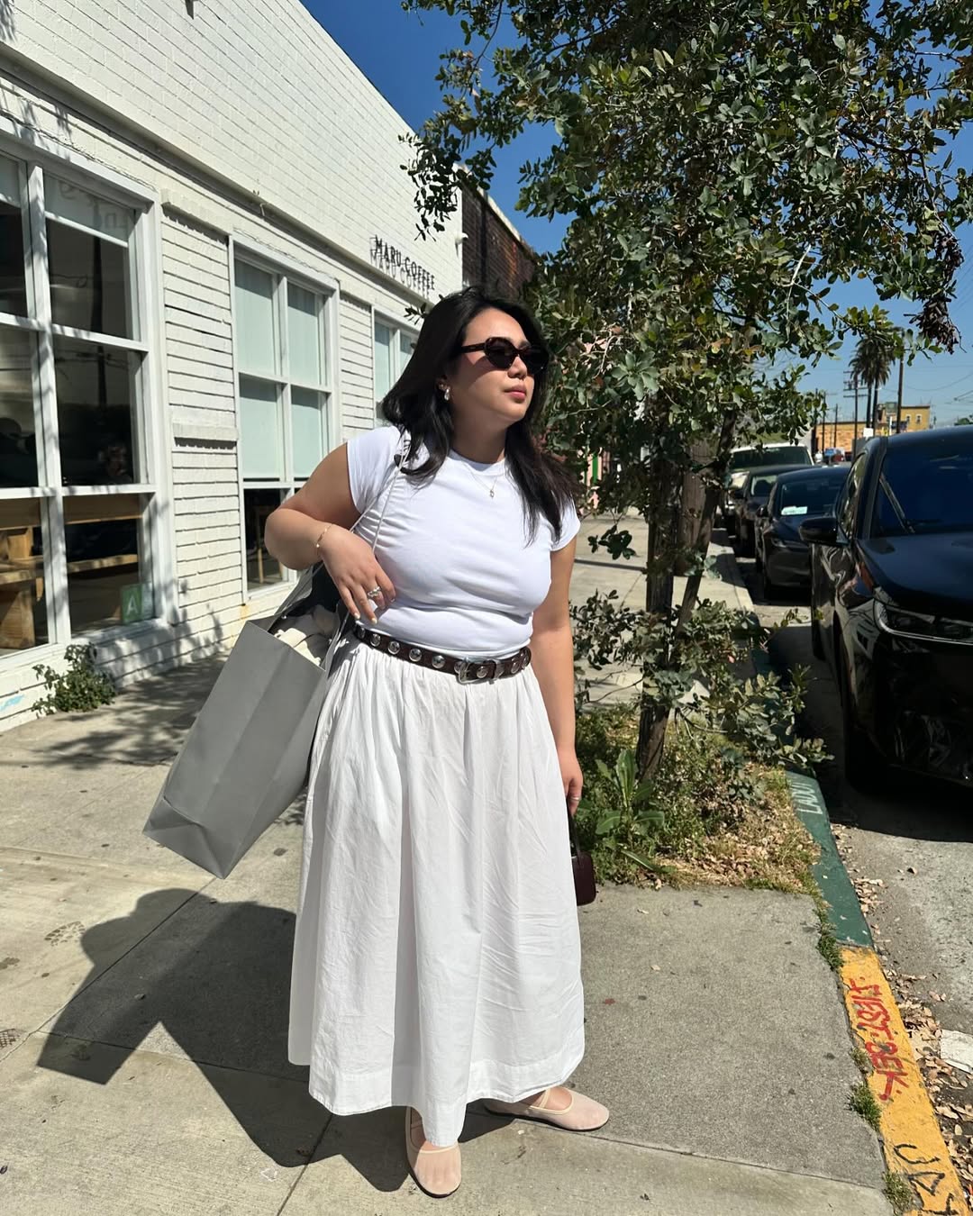 @marina_torres wears a white tee, cotton skirt and mesh ballet flats