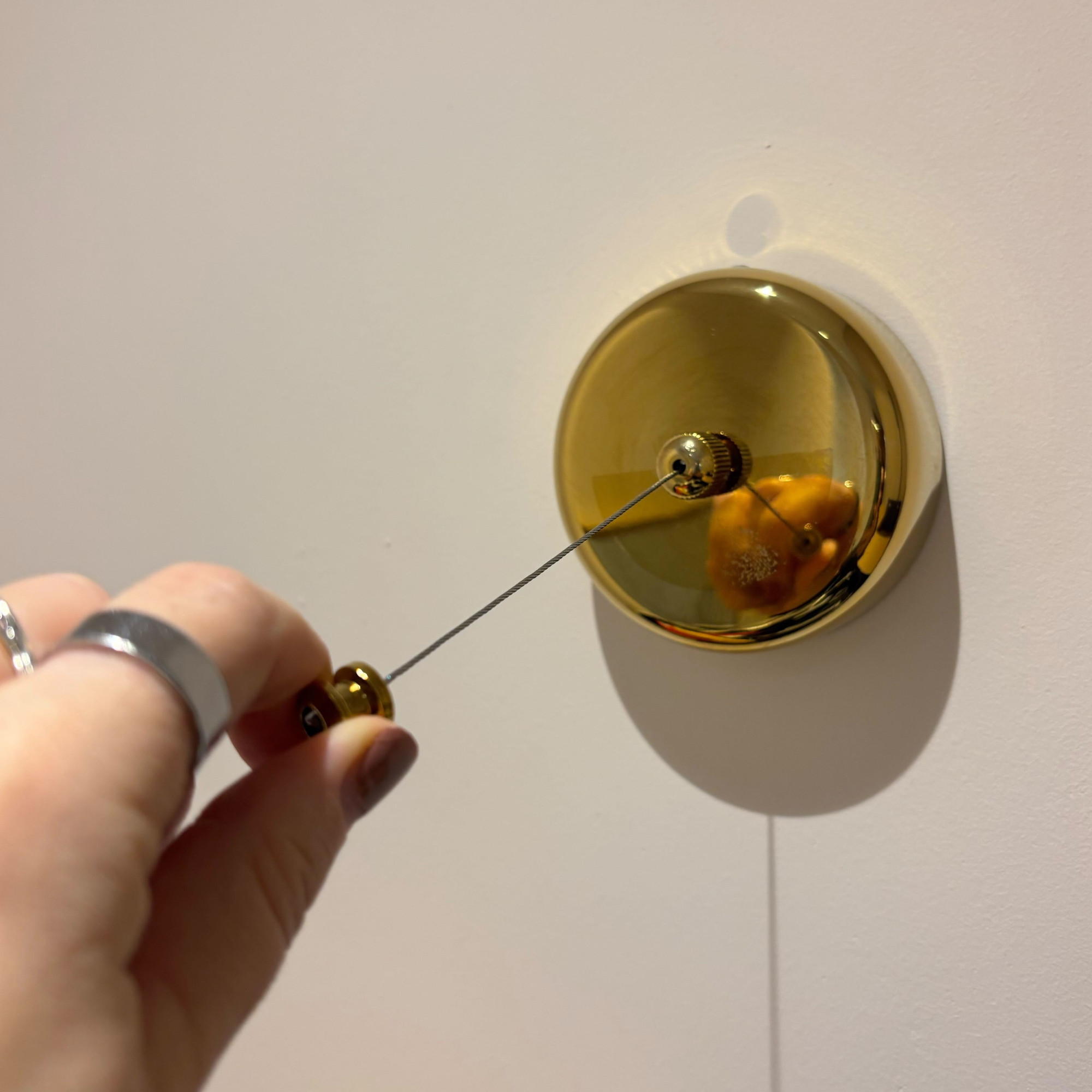 brass retractable clothes line with cord pulled