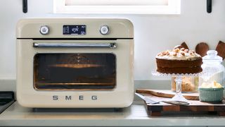 Smeg Countertop Air Fry Oven with Steam in Cream within a kitchen setting