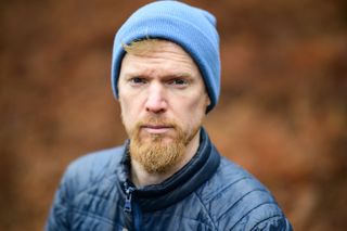 Viltrox AF 85mm F1.4 Pro lens sample gallery: man in a blue beanie, with blurry bronze-colored ferns in the background