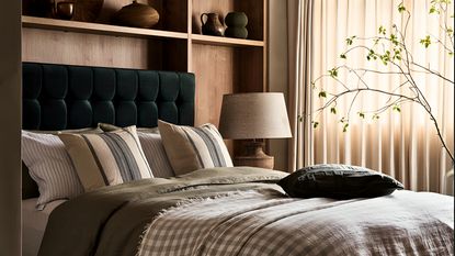 A green upholstered bed built into wooden shelving