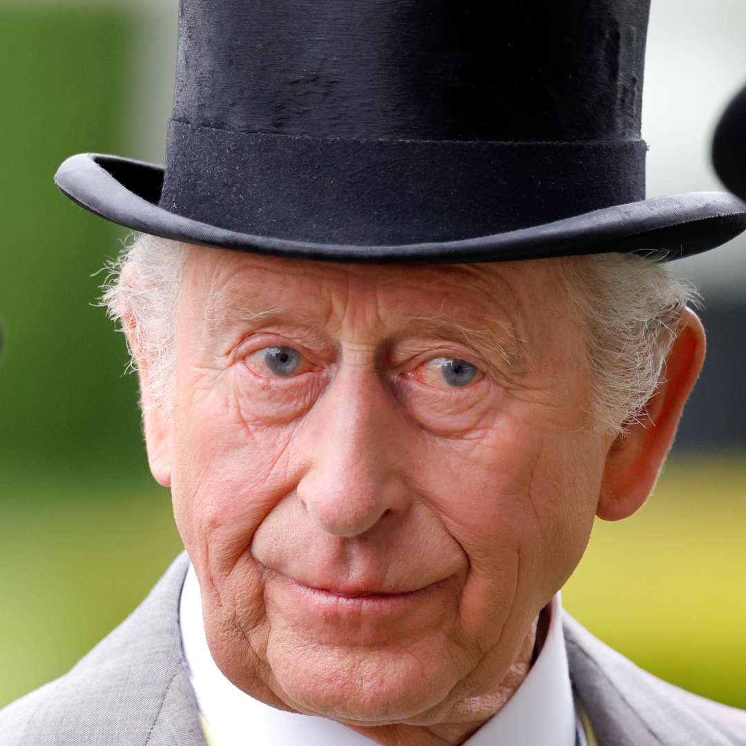 King Charles wearing a top hat and suit