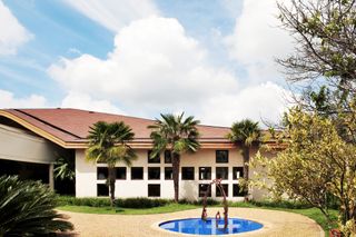 Building with blue circular pool and sculpture