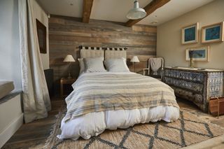 bedroom in a barn conversion with varied lighting design plan and timber cladding