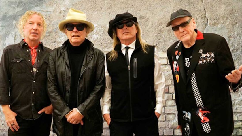Cheap Trick standing against a wall