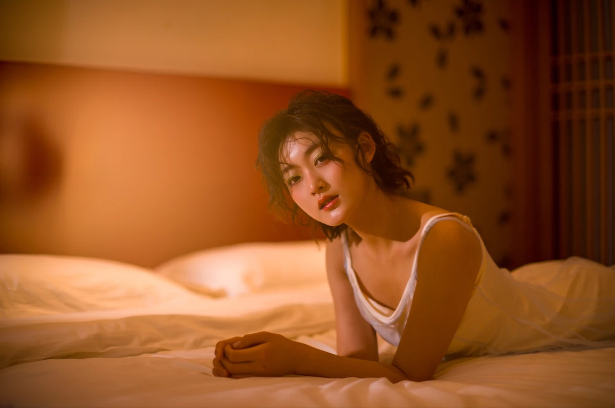 Portrait of person lying on bed captured with Lailens 50mm f/1.1