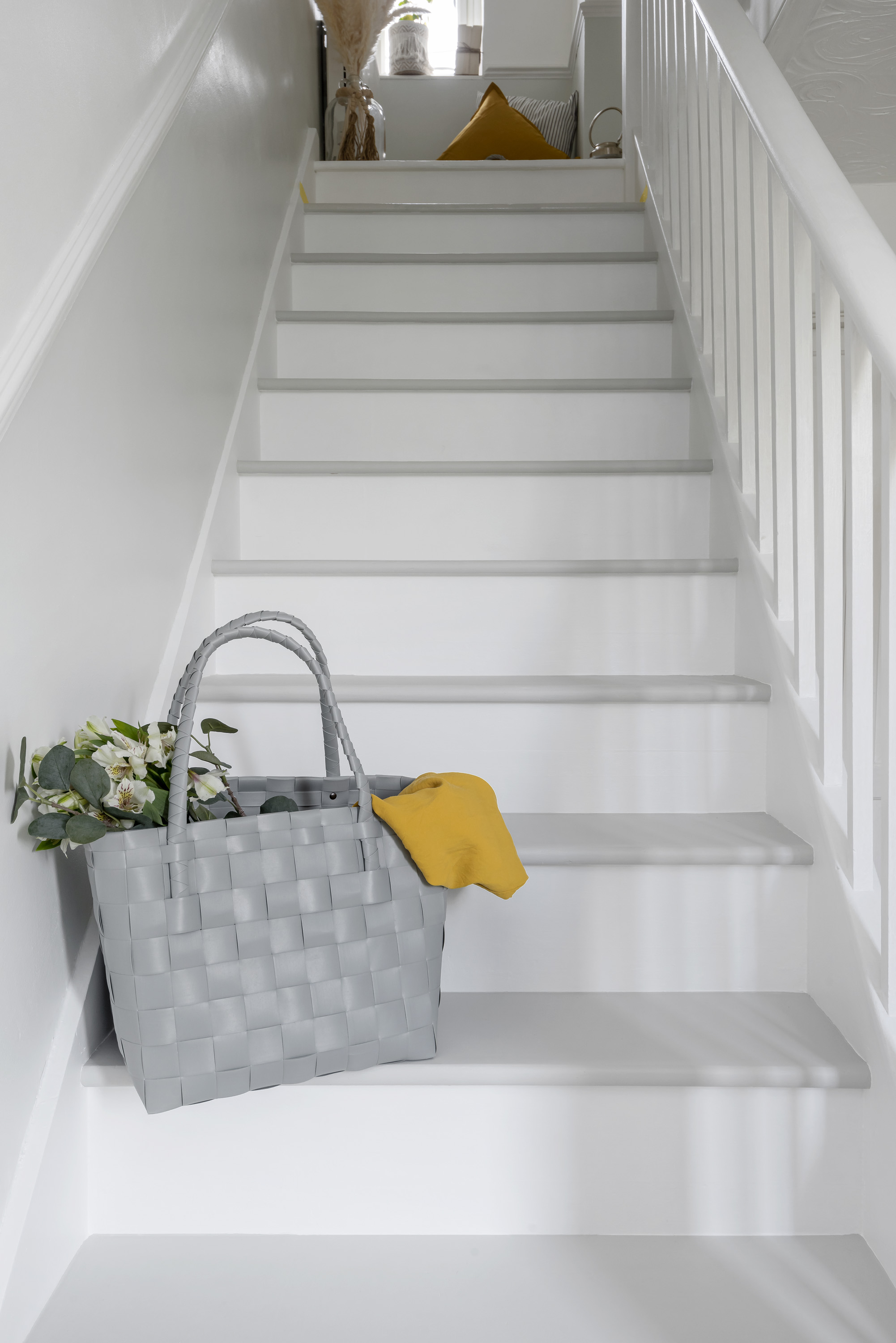 a staircase painted in grey and white tones with bag