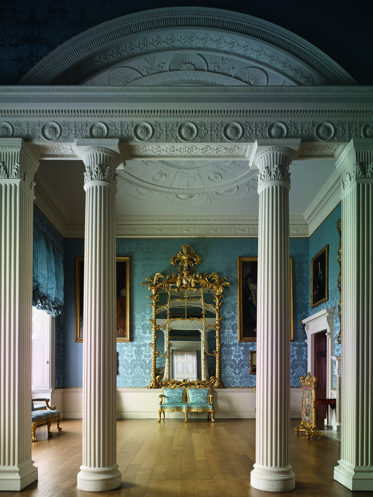 View of the state dressing room with its screen of columns flanked by mirrors with their palm tree motif frames at Kedleston Hall in Derbyshire.