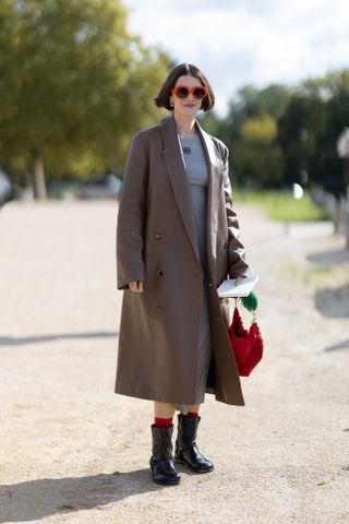 woman wearing short moto boots, coat, and sweater dress