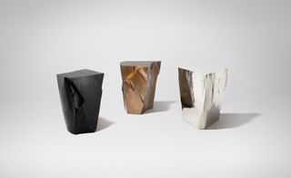 A group of 3 styatues shaped like icebergs in black, bronze and clear