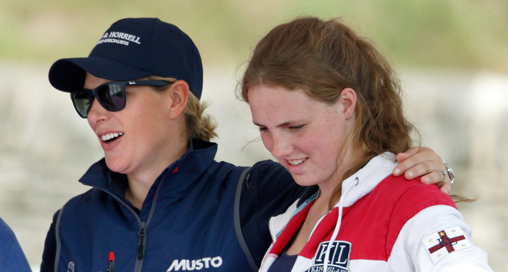 Zara Tindall wearing a blue jacket putting her arm around Stephanie Phillips